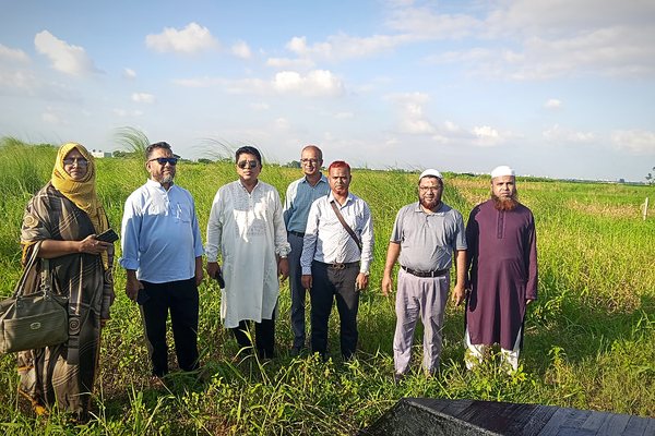 Inspection party of seven standing on the parcel under an open sky